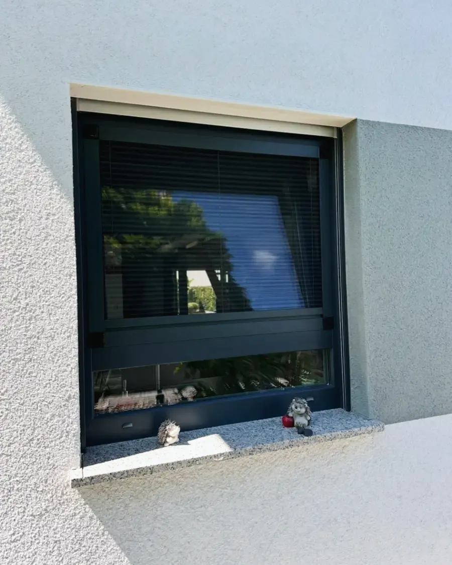 Insektenschutz an einem anthrazitfarbenen Fenster mit Fensterbank