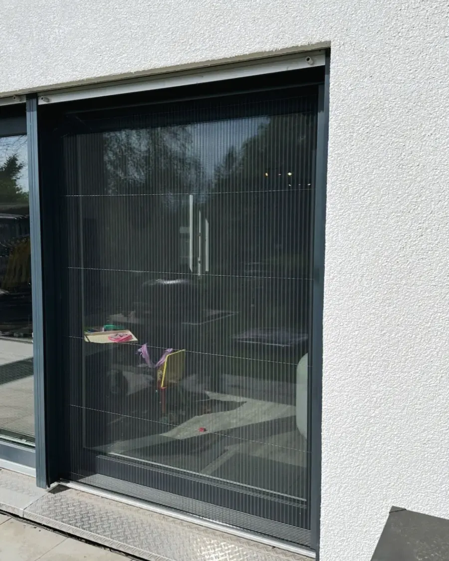 Plisseetür an einer Terrassentür in heller Putzfassade