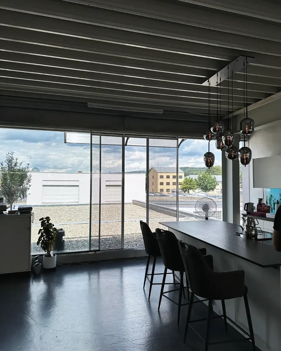 Plissee-Insektenschutz an der Panorama-Fensterfront eines Wohn- und Essbereichs